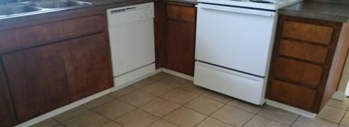 Kitchen shows the base of the white dishwasher, and white range.