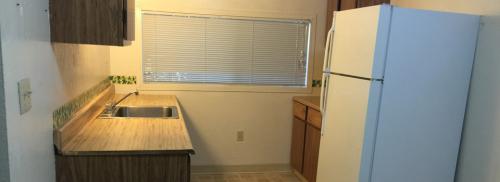 Kitchen shows counterspace, range, and white fridge.