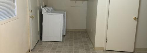 Towards the back of the kitchen shows the full size white washer and dryer.
