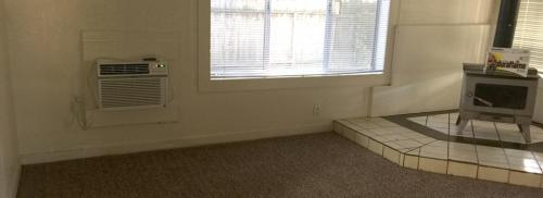Living Room shows a wall unit air conditioner to the left of the wood stove.