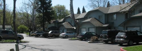An exterior photo of the property at Humboldt Ridge shows several blue townhouses.