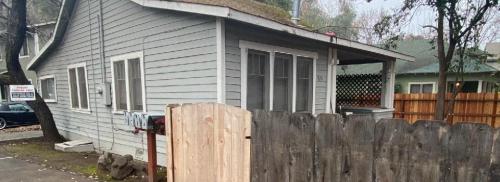 Outside view of the side of the house and its connecting fence.
